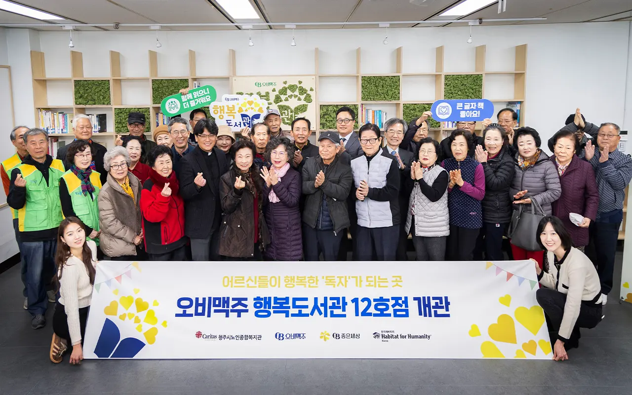 오비맥주 사회공헌 사업 ‘행복도서관’ 12호점 개관식에서 지역 어르신들과 기념촬영하는 모습