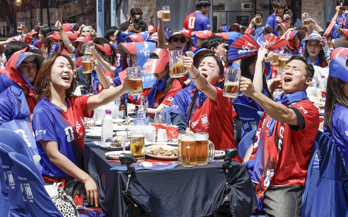 카스 뷰잉펍에서 대한민국 축구 대표팀을 응원하며 맥주잔을 들어 건배하는 축구 팬들
